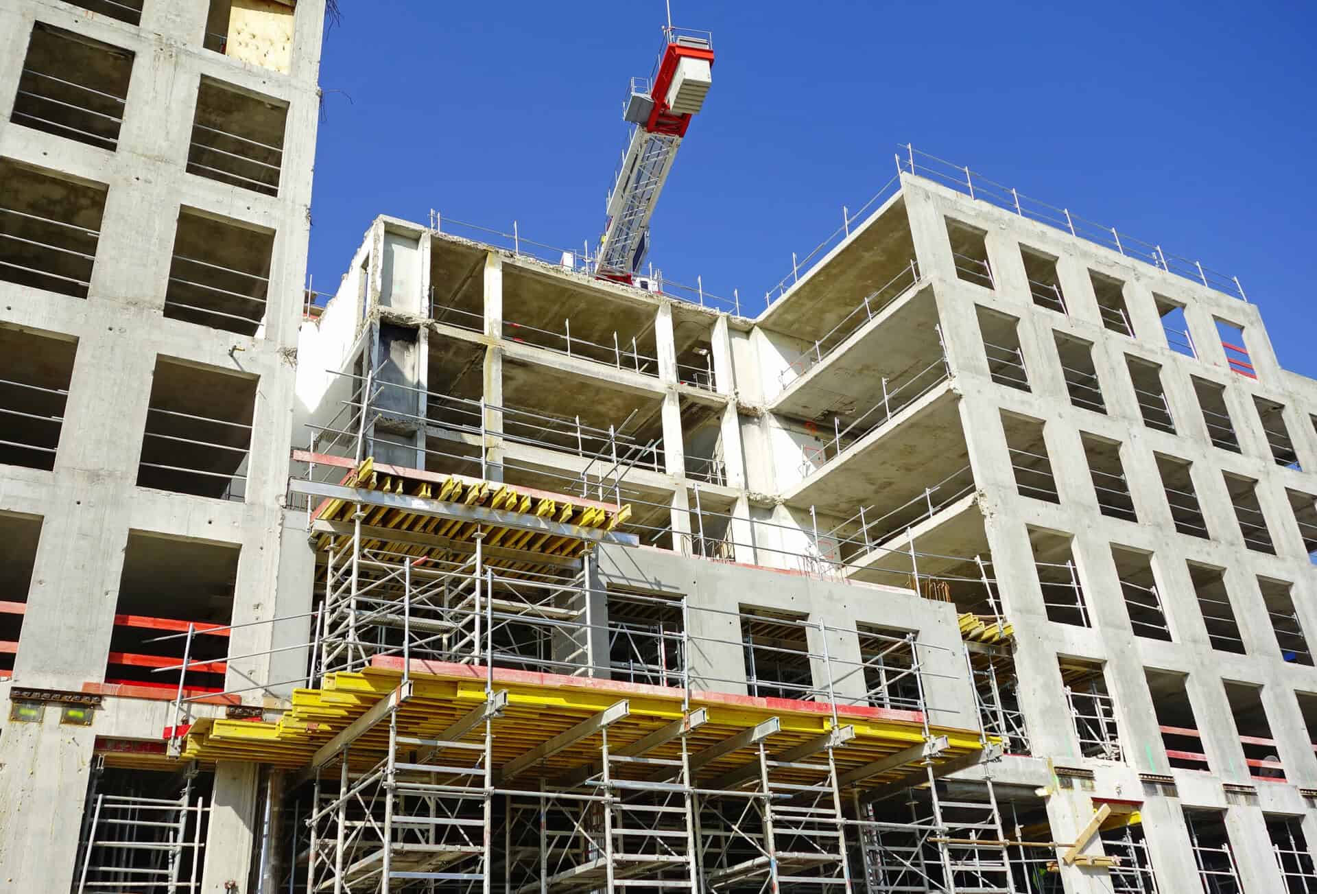 chantier d'un immeuble en construction avec une grue et des échaffaudages